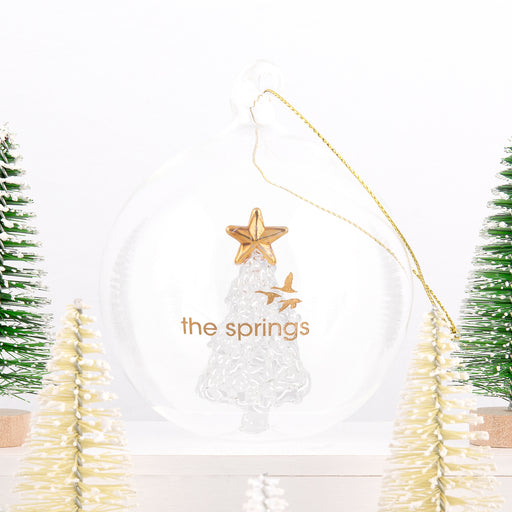 Custom branded glass ornament featuring internal glass tree and gold star, ideal for client gifting.