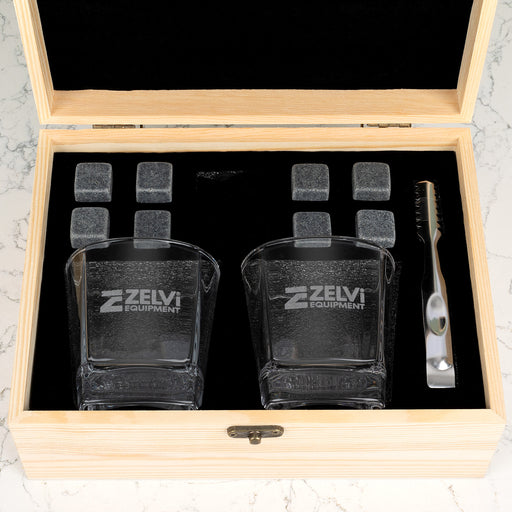 Branded whiskey gift set with company logo engraving on premium glassware, complete with reusable stones and accessories for client gifting.