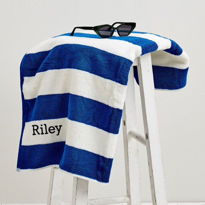Royal blue striped kids’ towel with personalised black embroidery – ideal for summer fun
