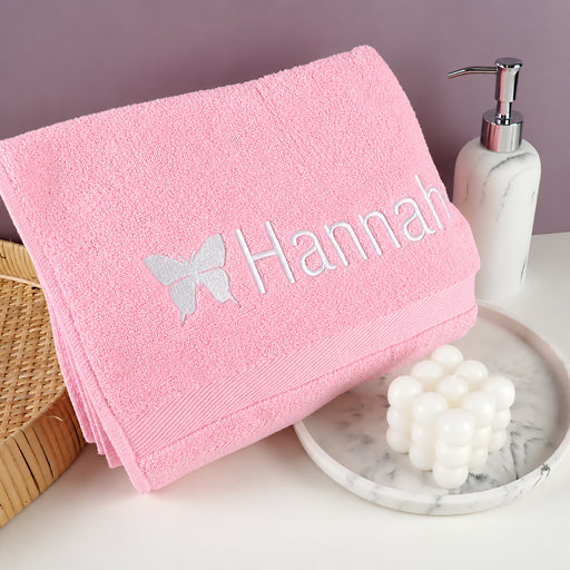 Personalised pink kids bath towel with embroidered name and butterfly design, made from soft 100% cotton.