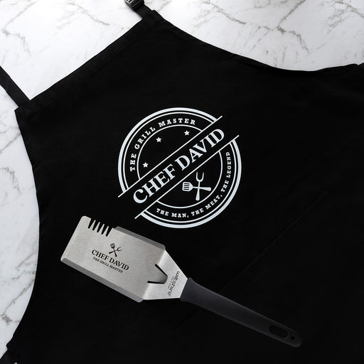 Personalised BBQ hamper with custom apron and engraved stainless steel BBQ tool featuring The Grill Master design.
