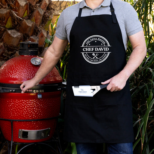 The Grill Master BBQ gift set featuring a personalised apron and laser engraved stainless steel BBQ tool for Dad.
