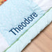 Close-up of custom name embroidery on safari-themed cotton baby blanket and play mat.