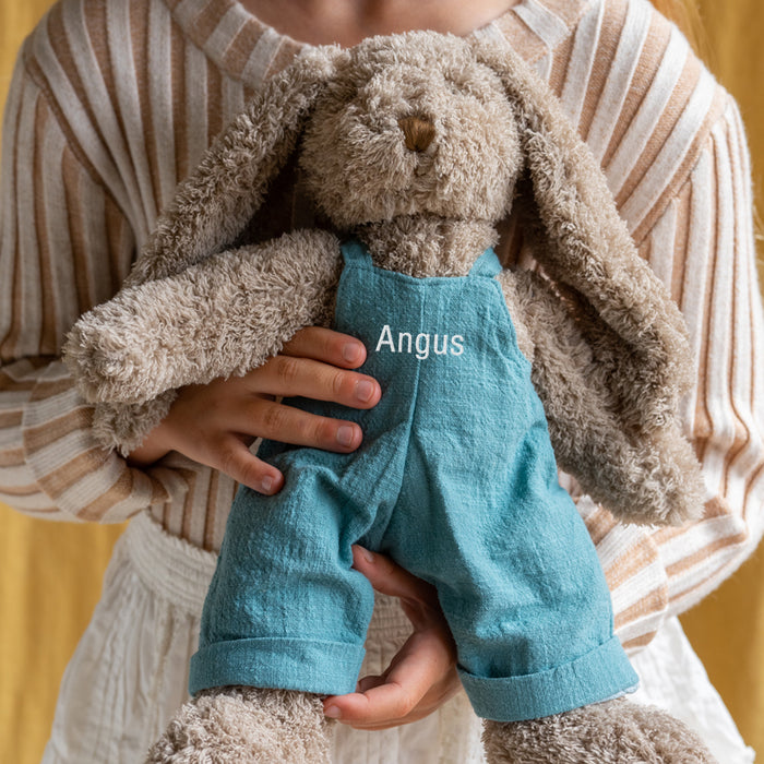 Soft and cuddly personalised bunny toy standing 40cm tall, featuring removable blue overalls embroidered with a name in your choice of thread colour.