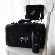 Personalised gym hamper with an embroidered sports bag, engraved protein shaker and matching black gym towel.