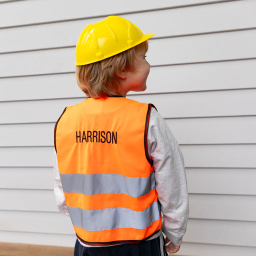 Child wearing bright orange tradie style vest with reflective tape