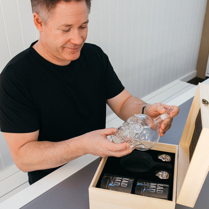 Glass decanter shaped like a skull with matching engraved glasses