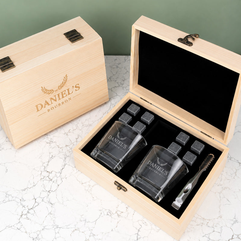 Personalised whiskey gift set with two engraved square glasses, eight reusable whiskey stones and a black velvet storage bag in a wooden gift box.